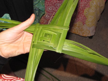 Using reeds to weave a St Brigid's cross