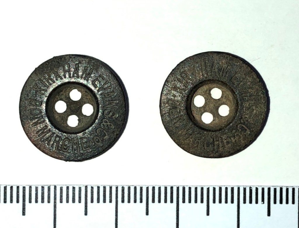 Two trouser buttons, stamped with words KIRKHAM EVANS & CO BON MARCHE