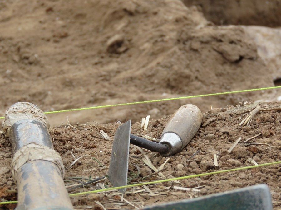 Trowel at edge of trench.
